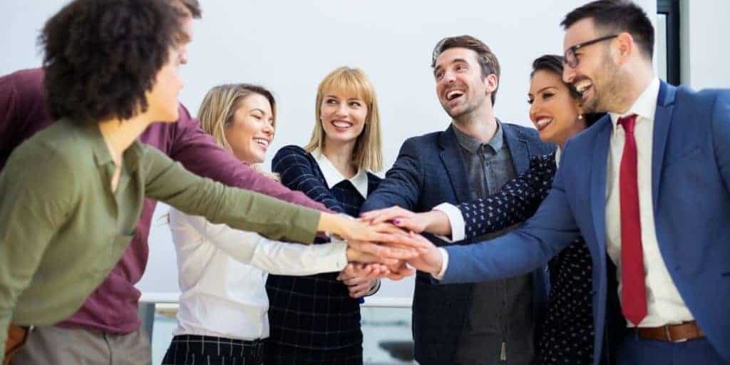 people in office hands together