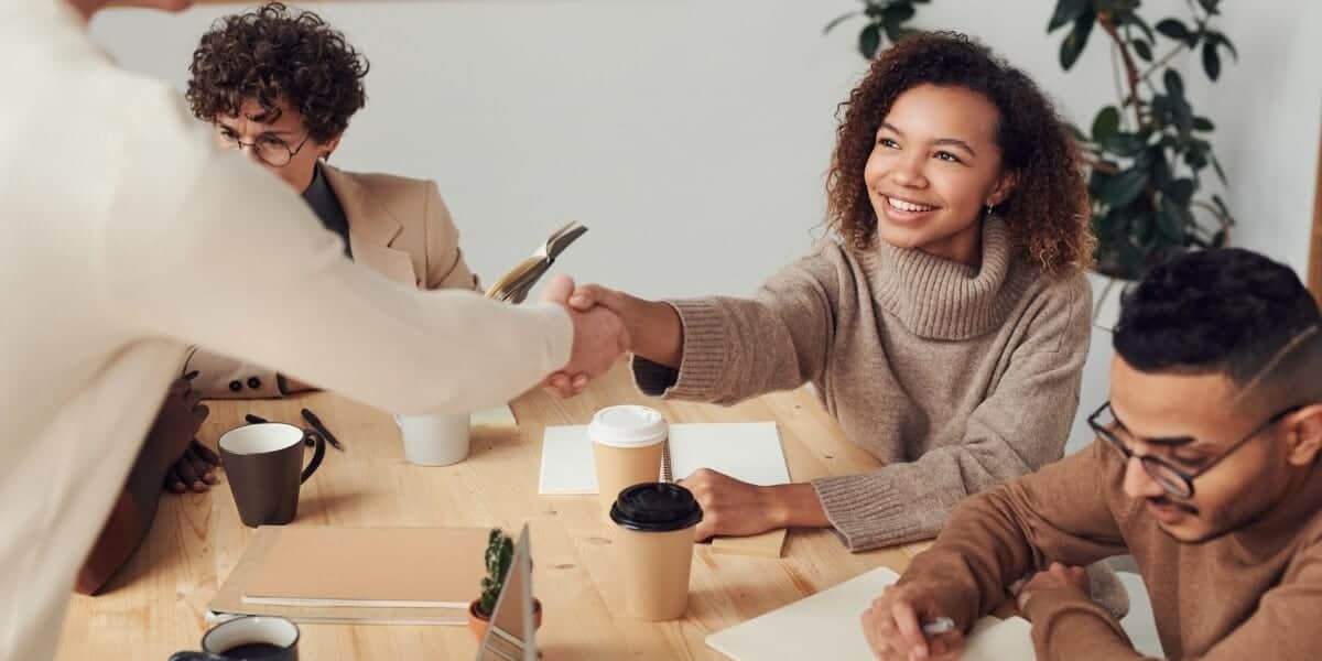 woman happy shaking coworkers hand