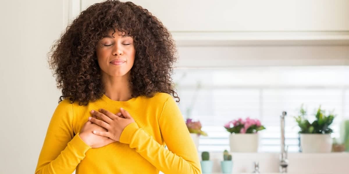 woman with hands on chest in gratitude