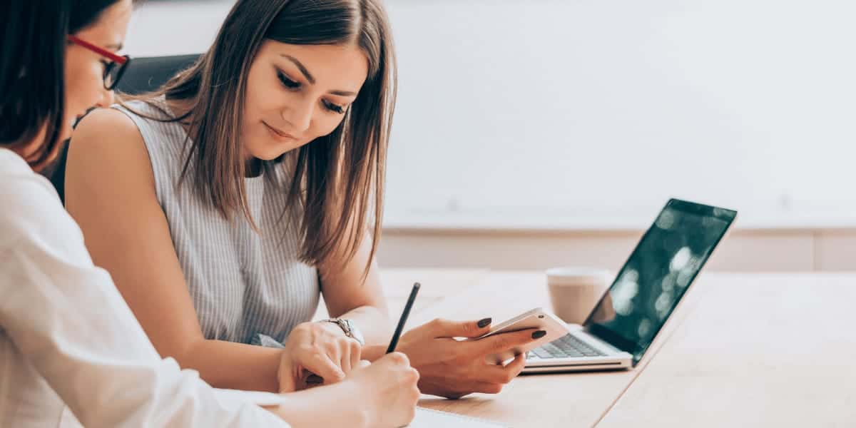 Woman with phone meeting with coworker